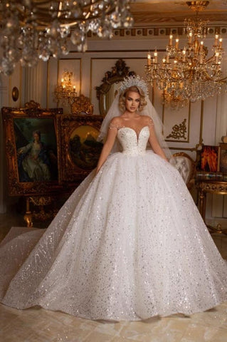 Precioso vestido de novia de corte princesa, sin mangas, con escote corazón y hombros descubiertos, con purpurina.