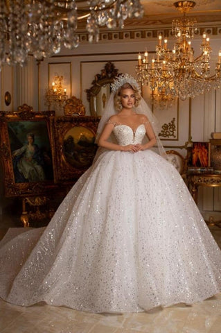 Precioso vestido de novia de corte princesa, sin mangas, con escote corazón y hombros descubiertos, con purpurina.