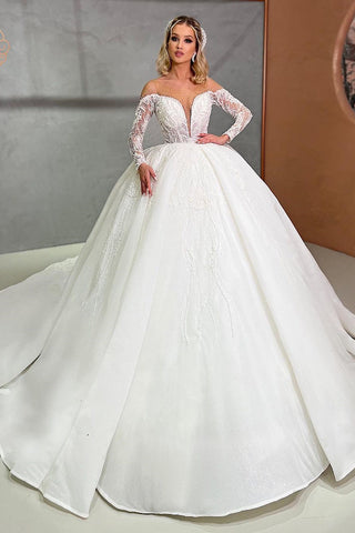 Precioso vestido de novia de corte princesa con escote corazón, mangas largas y pedrería.