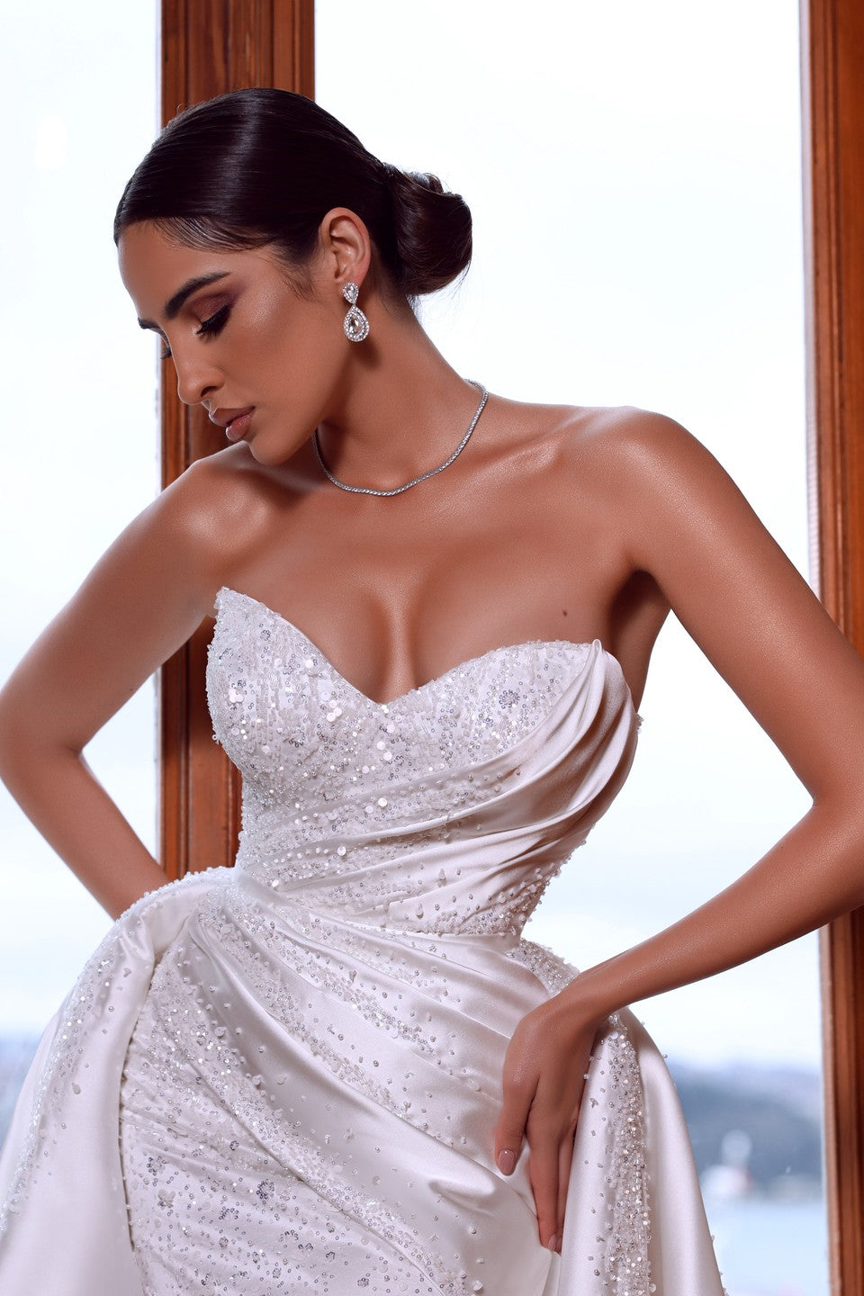 Magnifique robe de mariée blanche sans manches à décolleté cœur ornée de perles et traîne amovible.