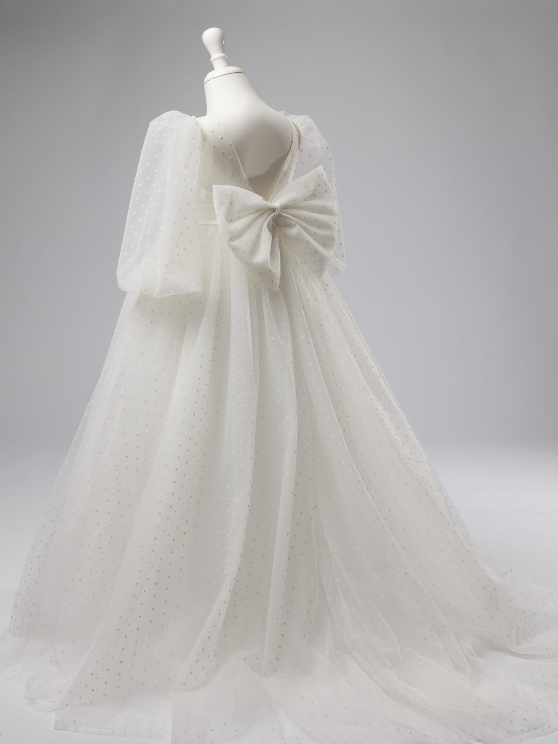 Elegante vestido de niña de las flores para la Primera Comunión, de tul con lunares, mangas abullonadas y cola corta. 