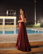 Vestido de fiesta largo burdeos de corte A, escote en V, espalda descubierta y abertura.