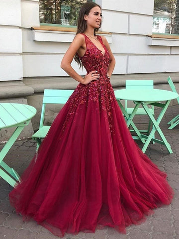 Robe de soirée longue bordeaux en tulle et dentelle florale, col en V, coupe trapèze, ornée de fleurs.