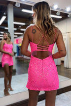 Robe courte rose fuchsia moulante à fines bretelles et pompons, idéale pour un bal de promo.