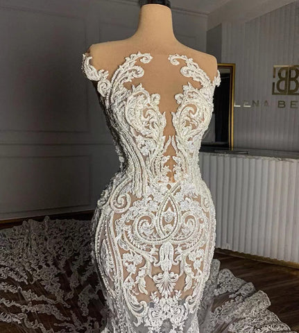 Vestido de novia largo de tul con cuello joya, corte sirena, bordado con cuentas y apliques de encaje.