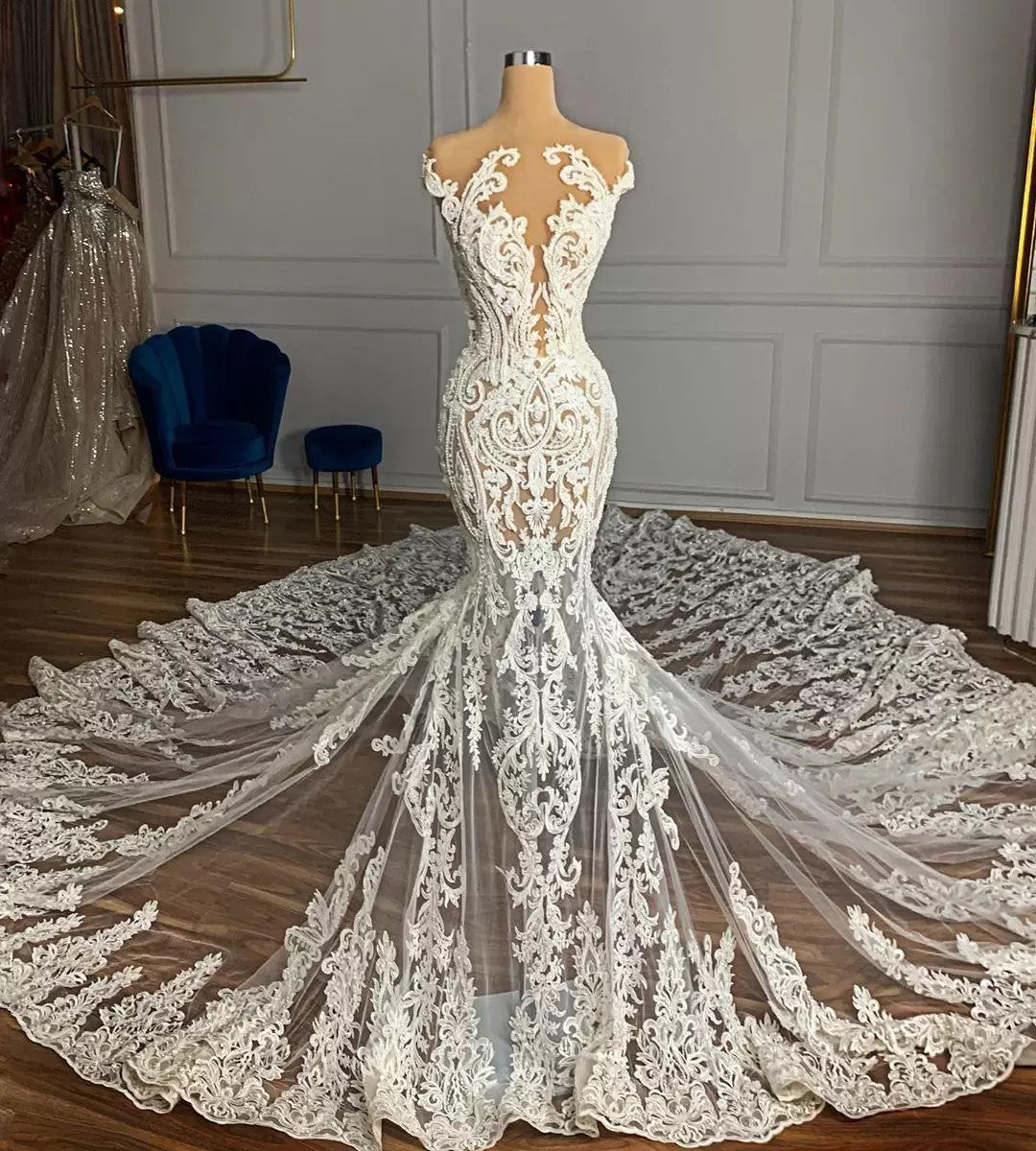 Robe de mariée sirène de luxe en tulle à col bijou et perles, ornée d'appliqués de dentelle.