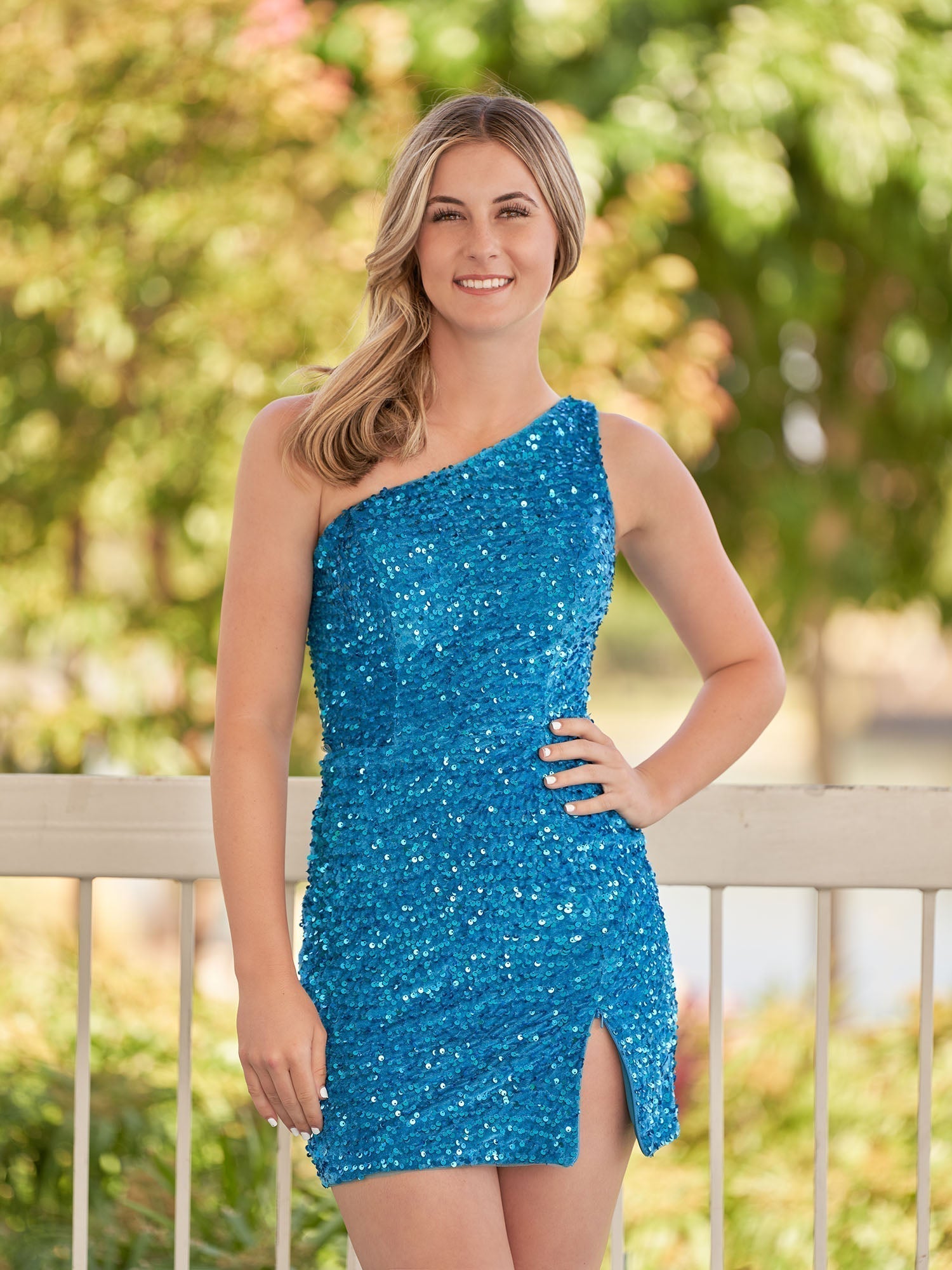 Vestido de fiesta azul de lentejuelas con un solo hombro y abertura, estilo tubo.