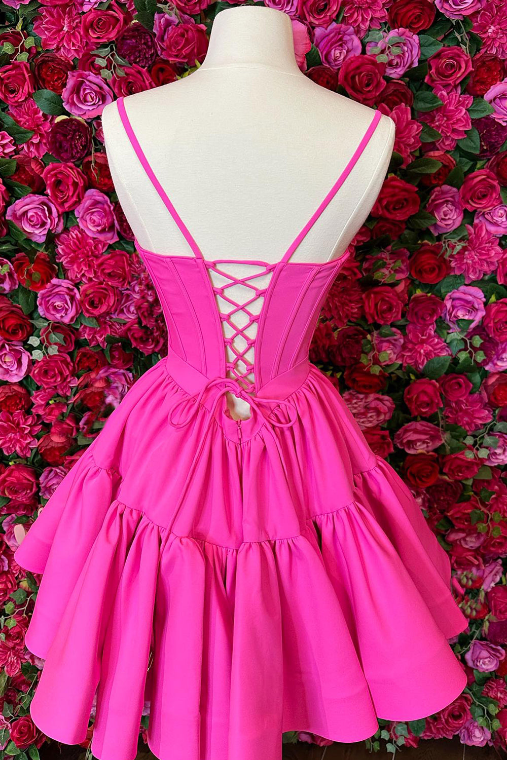 Lindo vestido corto rosa fucsia de tirantes finos con corte en A y espalda cruzada, ideal para fiestas de bienvenida.