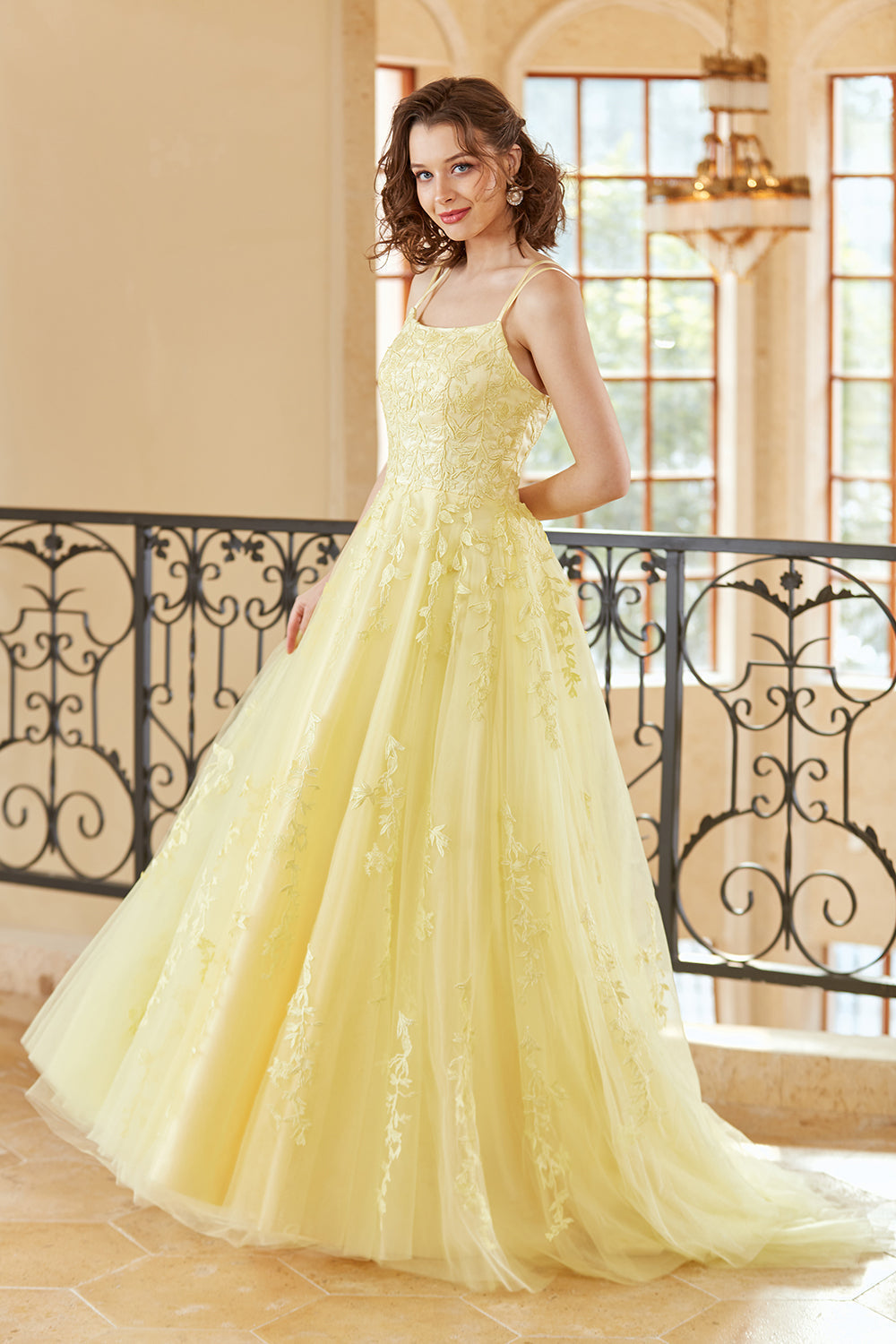 Magnifique robe de bal longue jaune à bretelles spaghetti et coupe trapèze, ornée d'appliqués.