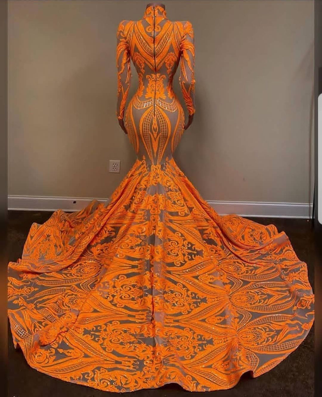 Vestido de fiesta naranja estilo sirena con cuello alto, mangas largas y encaje de lentejuelas.