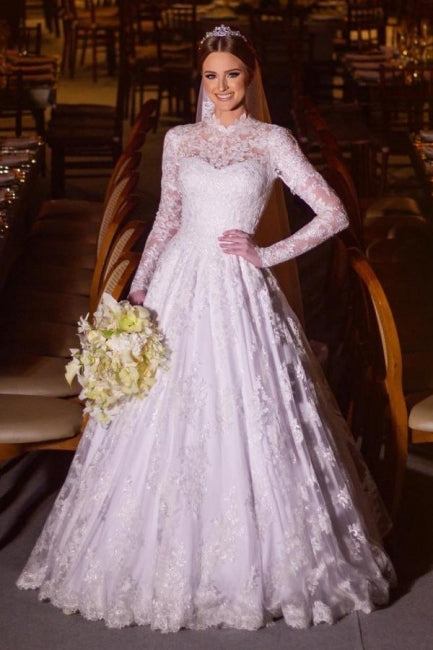 Robe de mariée blanche charmante, coupe trapèze, col montant, manches longues, en dentelle et ornée d'appliqués