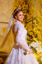 Robe de mariée blanche charmante, coupe trapèze, col montant, manches longues, en dentelle et ornée d'appliqués
