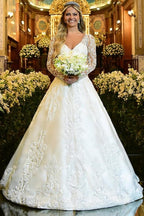 Robe de mariée blanche charmante, coupe trapèze, décolleté cœur, manches longues, en dentelle et ornée d'appliqués
