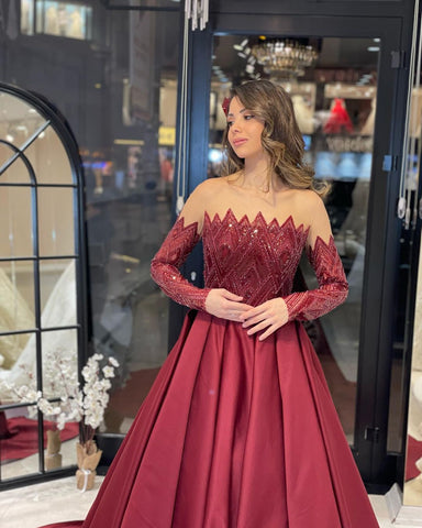 Robe de mariée charmante en satin, coupe trapèze, sans bretelles, manches longues et volants, longueur au sol.