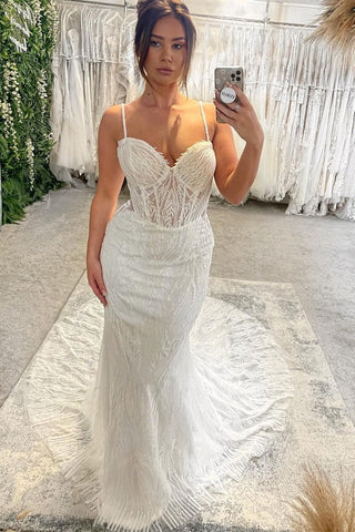 Robe de mariée sirène longue et ravissante, sans manches, à fines bretelles spaghetti et décolleté en cœur, avec traîne chapelle.