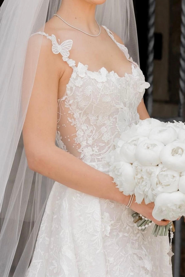 Robe de mariée longue ivoire sans manches en dentelle, charmante et avec traîne amovible.