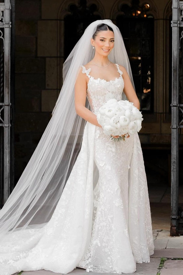 Robe de mariée longue ivoire sans manches en dentelle, charmante et avec traîne amovible.