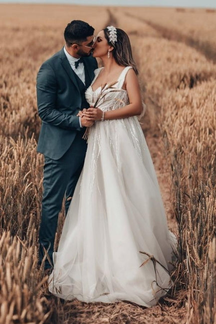 Robe de mariée blanche longue et charmante, coupe trapèze, sans manches, en tulle et dentelle.