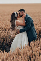 Robe de mariée blanche longue et charmante, coupe trapèze, sans manches, en tulle et dentelle.