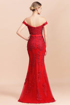 Robe de demoiselle d'honneur sirène rouge, décolletée épaules dénudées, ornée d'appliqués de dentelle, coupe ajustée.