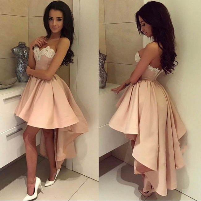 Robe de bal courte dorée sans manches avec appliques, coupe asymétrique et décolleté cœur en dentelle.