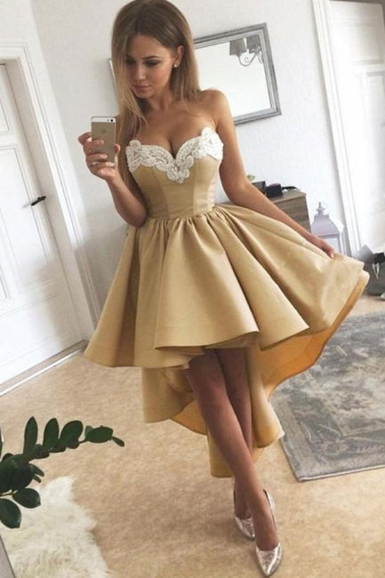 Robe de bal courte dorée sans manches avec appliques, coupe asymétrique et décolleté cœur en dentelle.
