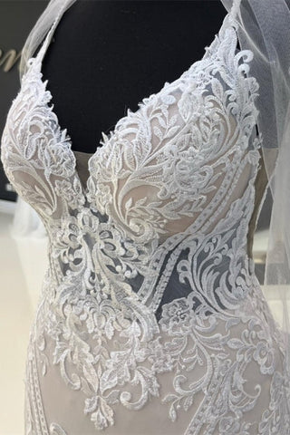 Encantador vestido de novia de encaje con tirantes finos y escote corazón, con cola de capilla.