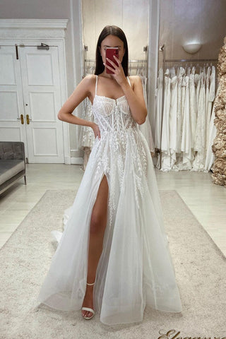 Elegante vestido de novia de corte A, tirantes finos, encaje y tul, sin mangas, con abertura.