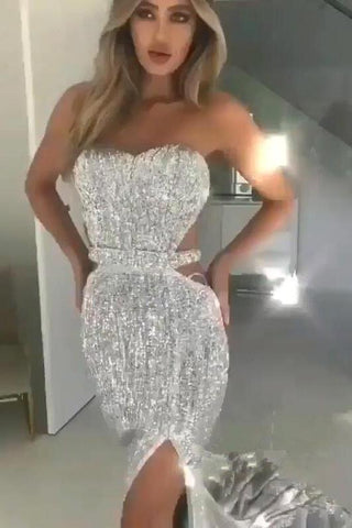 Vestido largo de fiesta elegante con top tubo negro, lentejuelas y abertura en la espalda blanca.