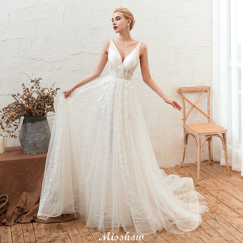 Elegante vestido de novia blanco de tul con escote en V profundo, espalda descubierta y cola de corte.