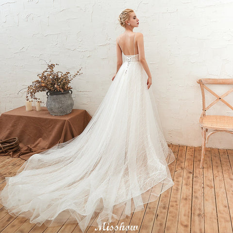 Elegante vestido de novia blanco de tul con escote en V profundo, espalda descubierta y cola de corte.