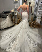 Robe de mariée sirène chic, longue jusqu'au sol, col en V, bretelles spaghetti, sans manches, traîne chapelle. Élégante robe de mariée sirène avec décolleté chapelle et traîne chapelle.