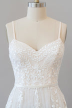 Robe de mariée chic longue en tulle à bretelles spaghetti et décolleté en cœur, ornée d'appliqués, coupe trapèze et bustier cœur