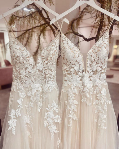 Elegante vestido de novia de tul con tirantes finos largos, escote en V y corte en A, con apliques de encaje.