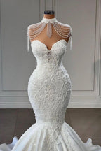 Robe de mariée sirène chapelle sans manches à encolure cœur, ornée d'appliqués de dentelle et de pompons, élégante et raffinée. 