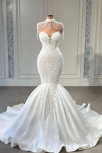 Robe de mariée sirène chapelle sans manches à encolure cœur, ornée d'appliqués de dentelle et de pompons, élégante et raffinée. 