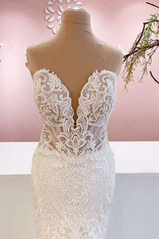 Elegante vestido de novia largo de corte sirena, con escote corazón, espalda descubierta y apliques de encaje.