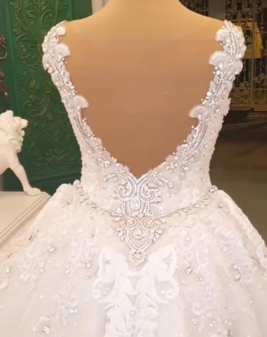 Elegante vestido de novia largo con escote corazón, tirantes finos, apliques de encaje y espalda descubierta con cristales