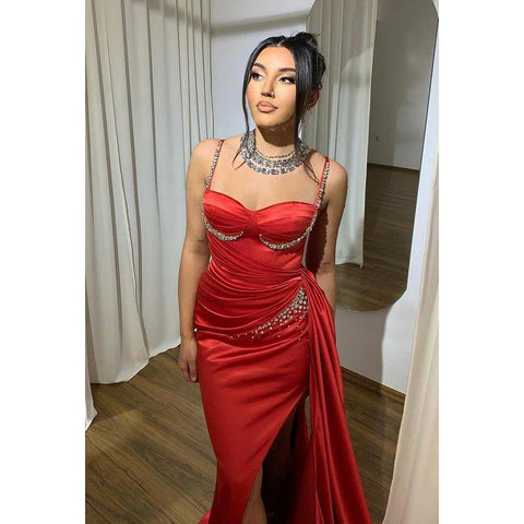 Vestido de fiesta de corte sirena con tirantes finos, abertura lateral y fruncido, con pedrería y alta costura.