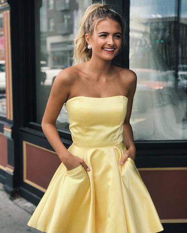 Lindos vestidos cortos de satén amarillo estilo A, sin tirantes, para baile de graduación o fiesta de bienvenida, con bolsillos.