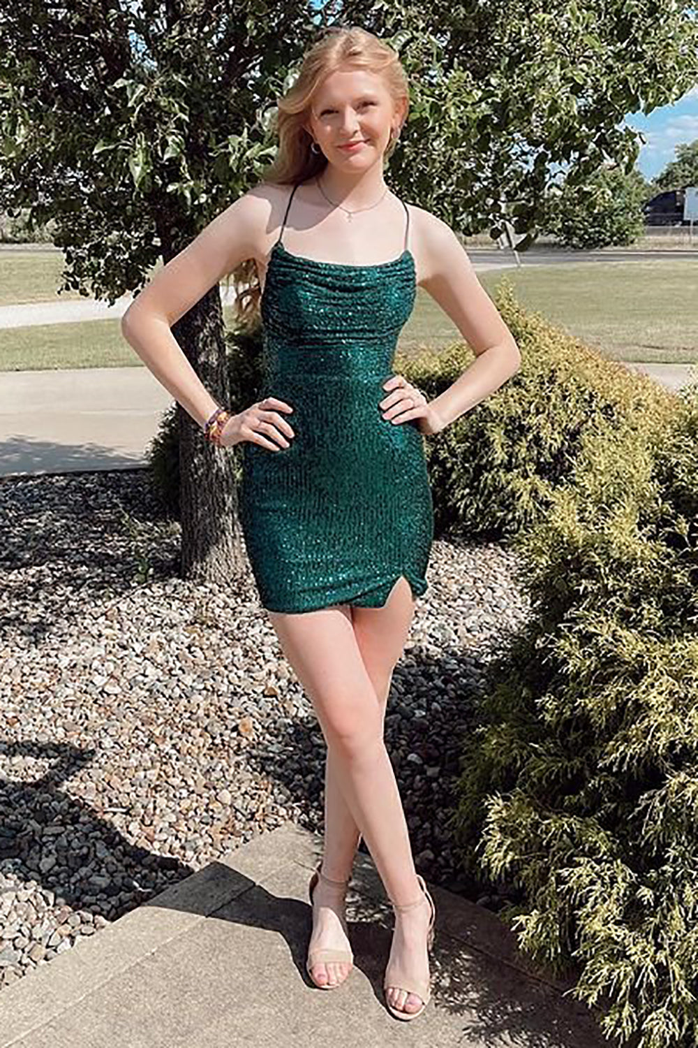 Vestido corto de fiesta verde con lentejuelas brillantes, tirantes finos y espalda cruzada.