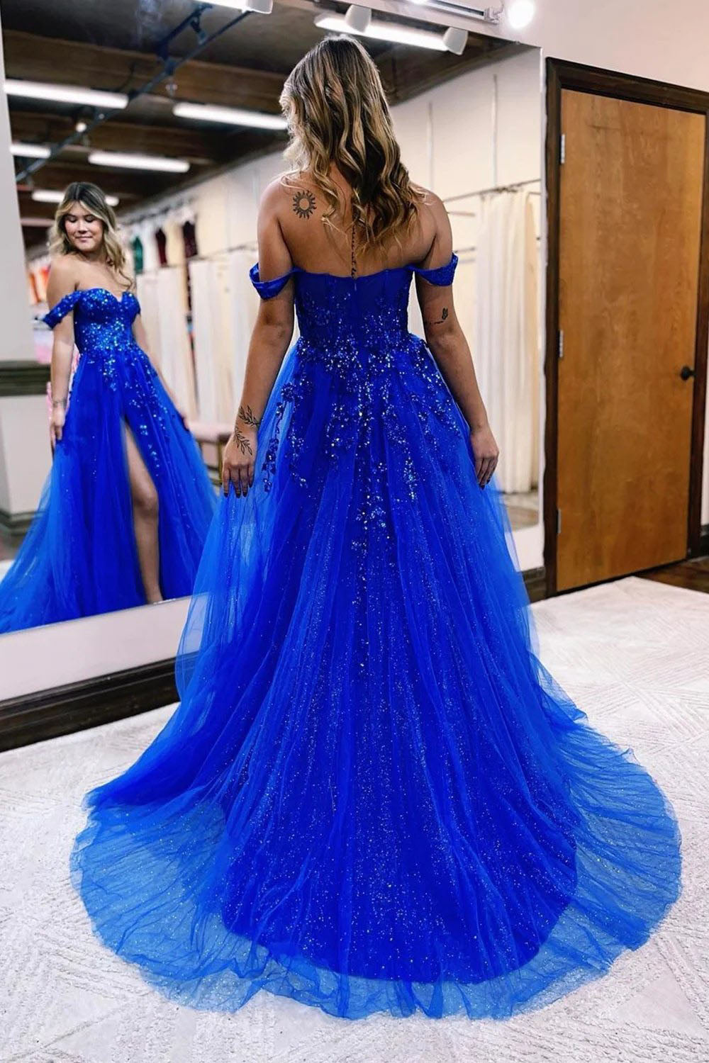 Vestido largo de fiesta azul marino con escote barco y abertura frontal.