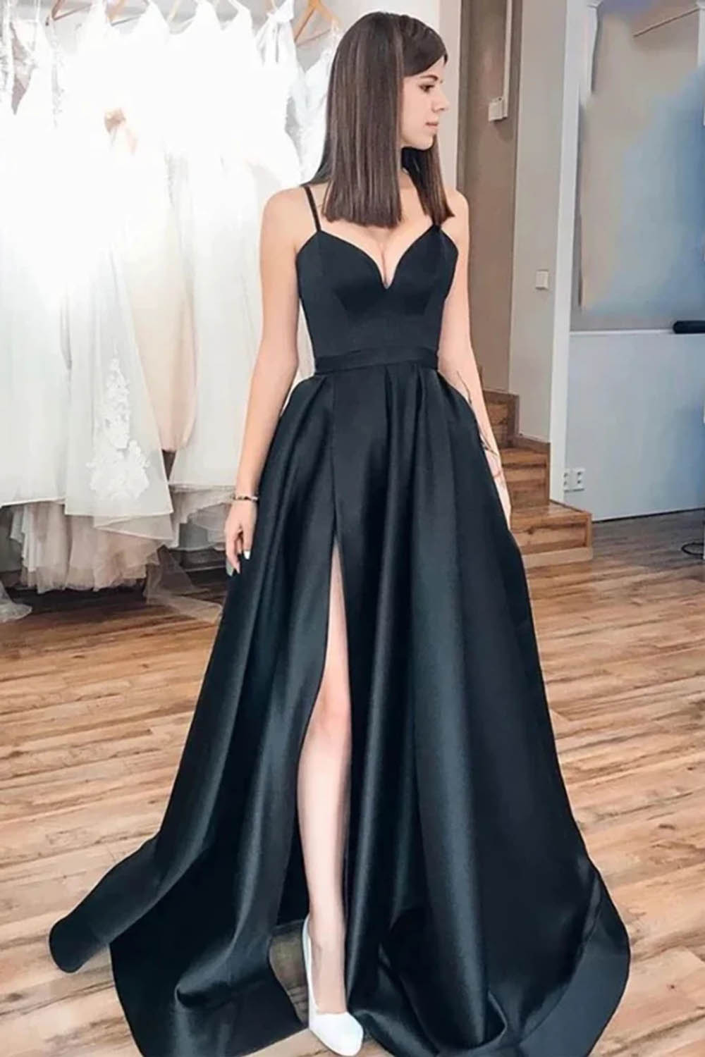Vestido largo de fiesta negro de corte A con tirantes finos y falda asimétrica.