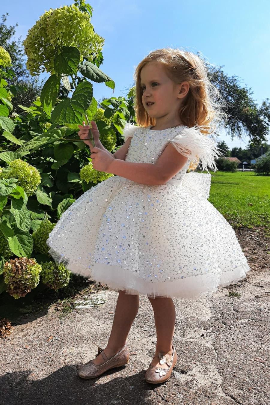 Ravissante robe de demoiselle d'honneur à sequins et manches courtes ornée de plumes.