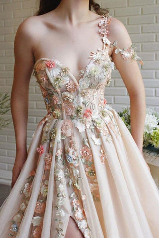 Robe de bal en tulle champagne avec fente, ornée d'appliqués de fleurs féeriques. Robe de bal fendue, ornée d'appliqués de fleurs féeriques. Tulle champagne.