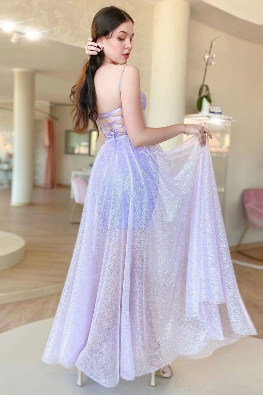 Vestido de fiesta lila con corsé, tirantes finos y corte en A, espalda cruzada.