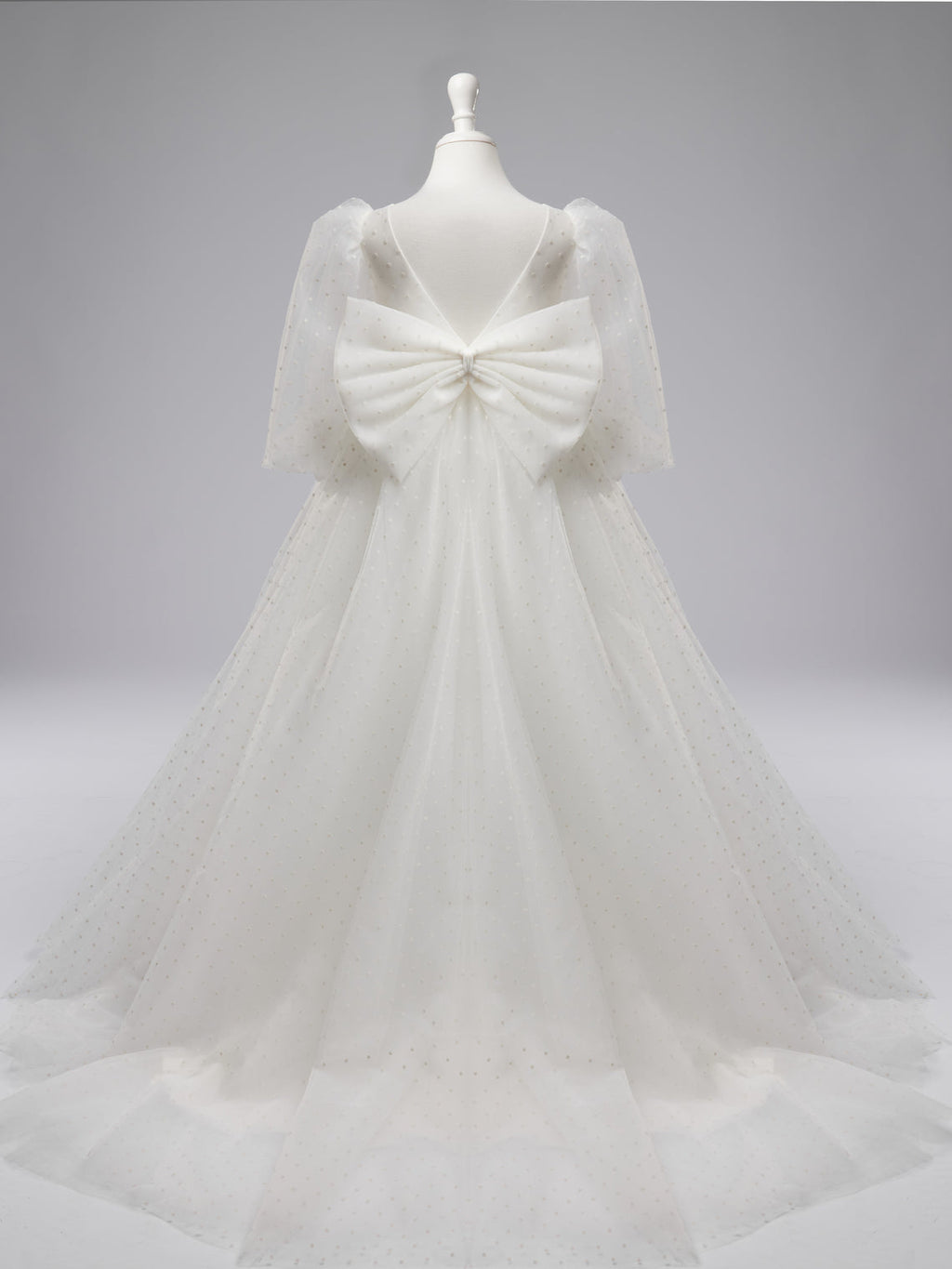 Elegante vestido de niña de las flores para la Primera Comunión, de tul con lunares, mangas abullonadas y cola corta. 