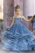 Vestido de niña de las flores de tul azul con tirantes finos y aplicaciones.