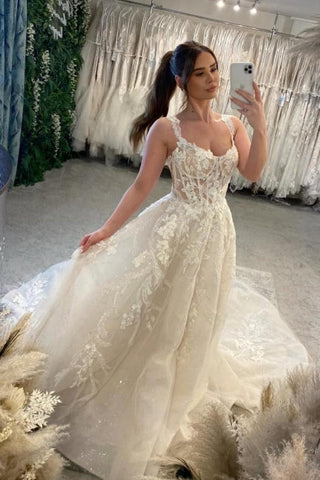 Vestido de novia blanco de encaje, corte en A, escote corazón, sin mangas y con cola.