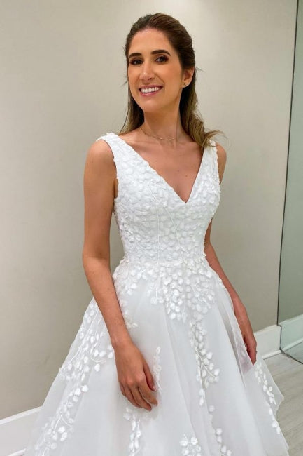 Robe de mariée blanche sans manches en dentelle, coupe trapèze, col en V et appliques, signée par un créateur
